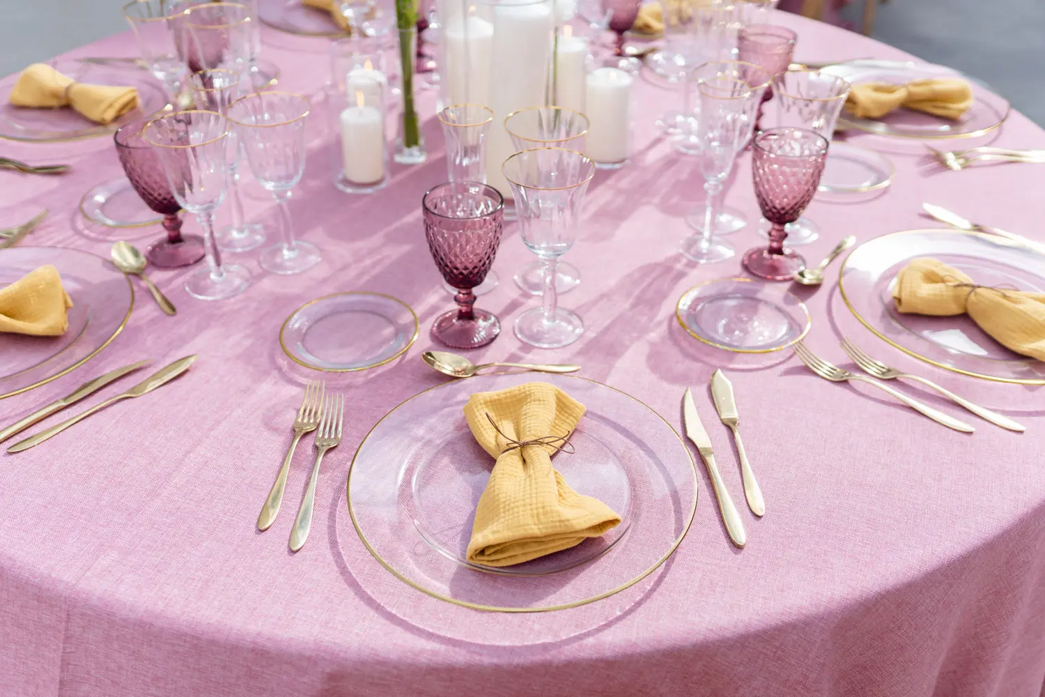 Detalle de cubertería dorada en mesa rosa