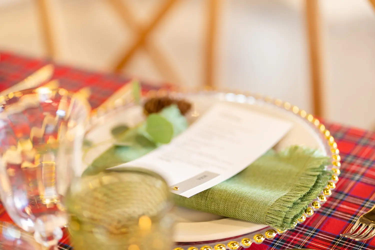 Mesa de Navidad con mantel tartán rojo y servilleta verde hoja