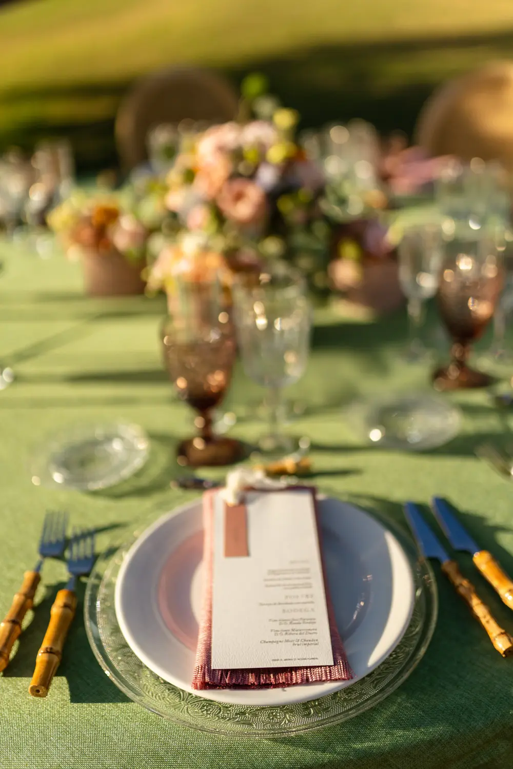 Cubertería de bambú en mesa de contraste verde y rosa